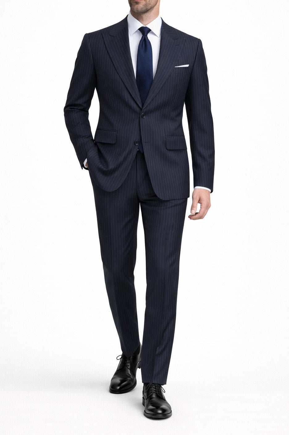 Man wearing a navy suit with a white shirt and black shoes on a white background