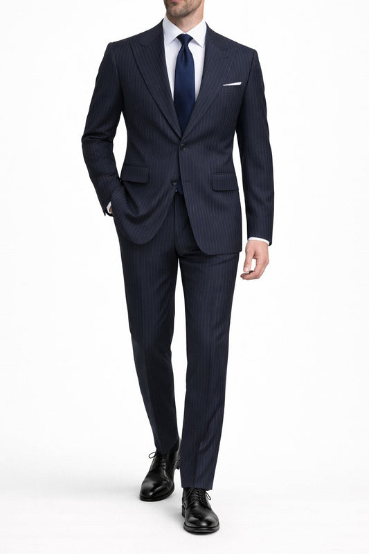 Man wearing a navy suit with a white shirt and black shoes on a white background