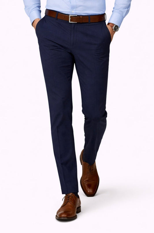 Man wearing a light blue dress shirt and navy pants on a white background