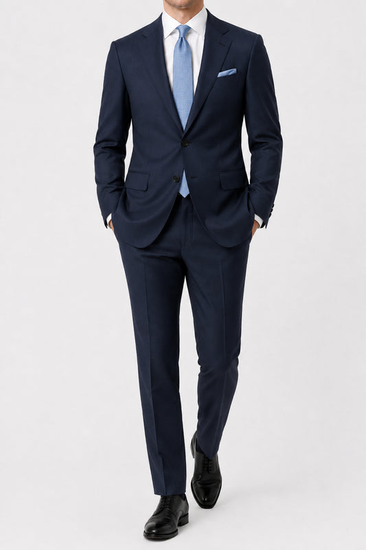 Navy suit with a light blue tie on a white background