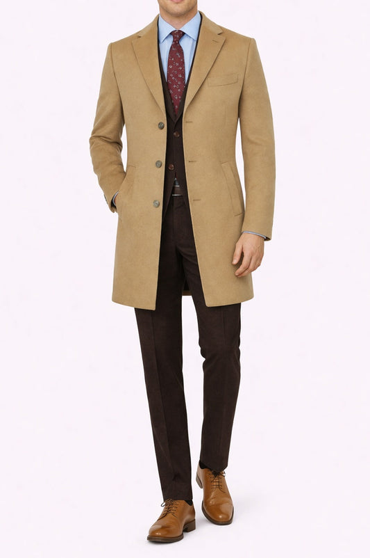 Man wearing a beige overcoat, brown suit, and tie on a white background