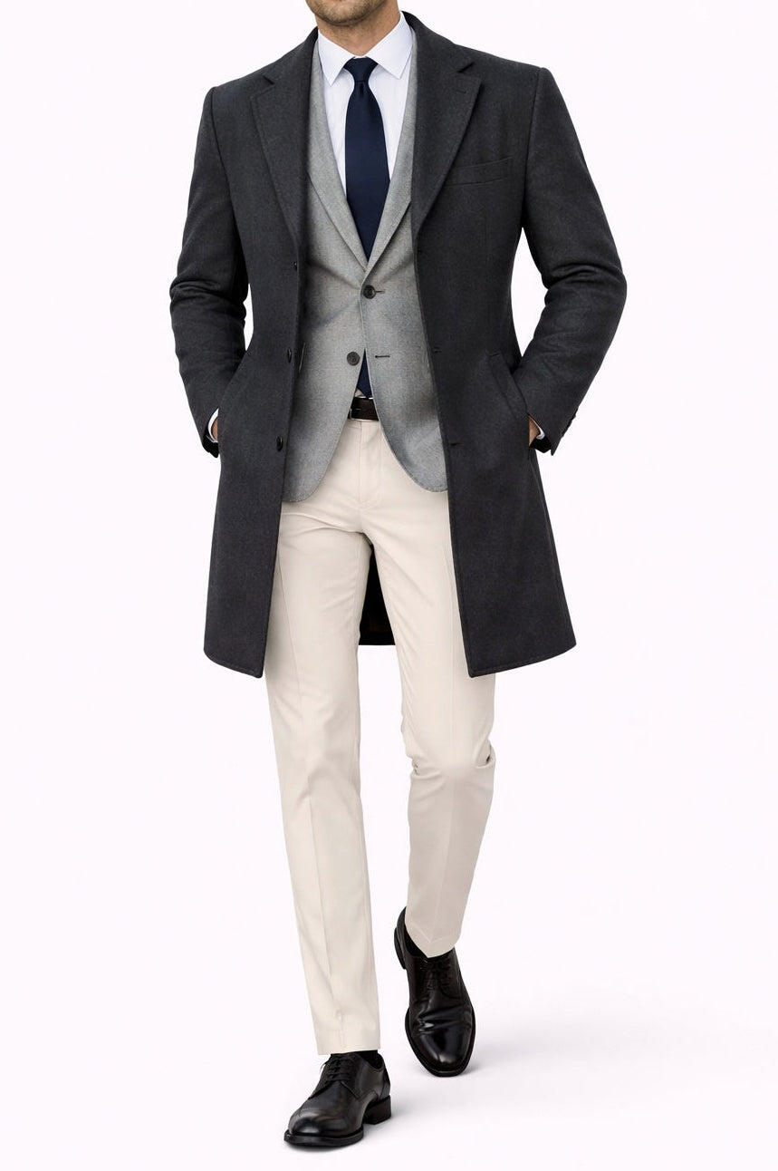 Man wearing a formal outfit with a coat, vest, and pants on a white background