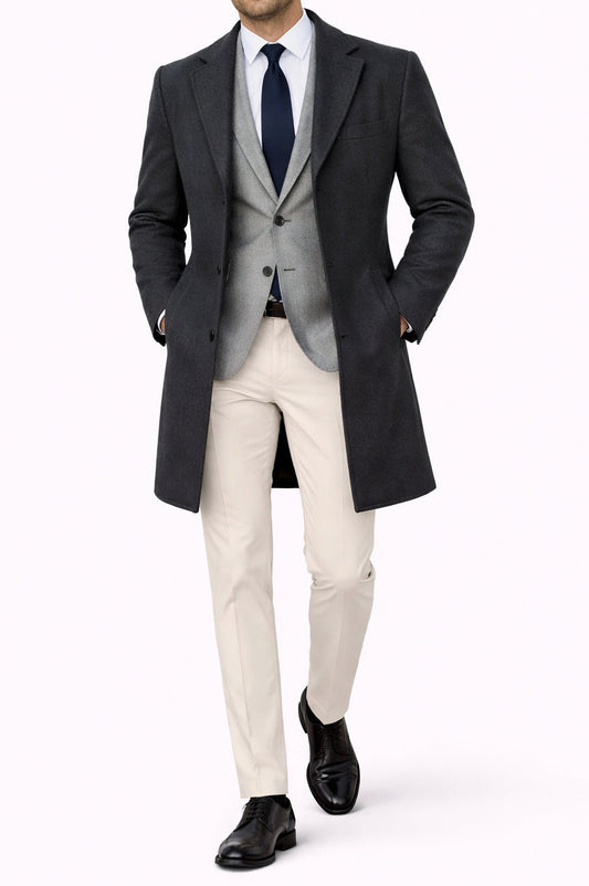 Man wearing a formal outfit with a coat, vest, and pants on a white background