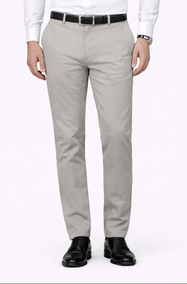 Man wearing a white dress shirt, gray pants, and black shoes on a white background